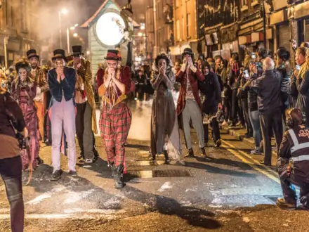 four lads dancing and whistling in halloween costumes